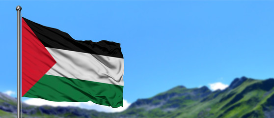 Palestine flag waving in the blue sky with green fields at mountain peak background. Nature theme.