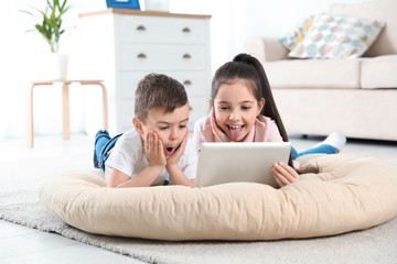 Little children using video chat on tablet at home