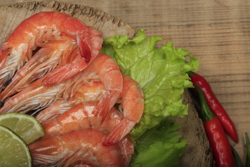shrimps with spices on wooden background