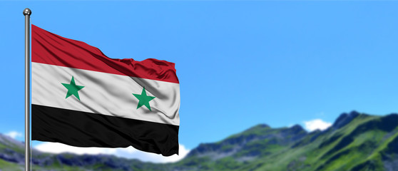 Syria flag waving in the blue sky with green fields at mountain peak background. Nature theme.
