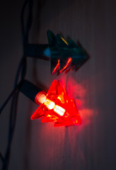 Red light garland Christmas tree hanging on the wall.