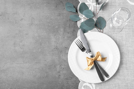 Stylish elegant table setting on grey background, top view. Space for text