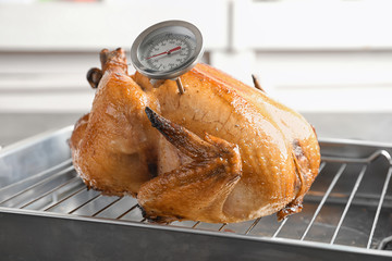 Roasted turkey with meat thermometer on baking rack