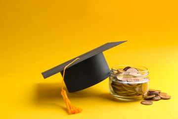 Glass jar, coins and graduation hat on color background. Space for text