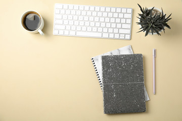 Blogger's workplace with notebooks and keyboard on color background, flat lay. Space for text