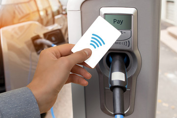 A man pays for charging an electric car.