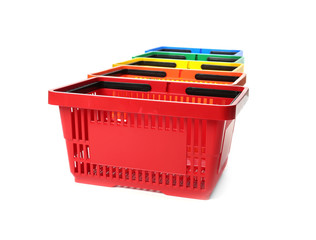 Fototapeta premium Colorful plastic shopping baskets on white background