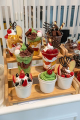 Variety of candies and sweet snack in cups on wooden rack