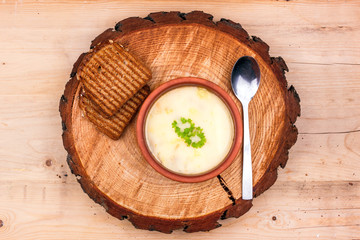 Fototapeta na wymiar Cheese soup in a clay plate with toasted bread