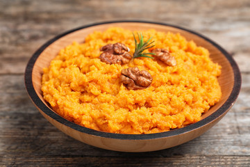 Bowl with mashed sweet potatoes on wooden table