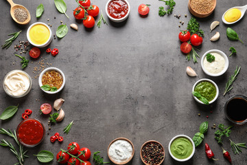 Frame made with different sauces and ingredients on gray background, flat lay. Space for text