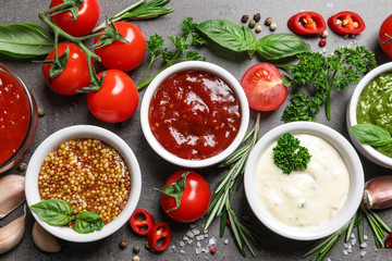 Flat lay composition with different sauces and ingredients on gray background