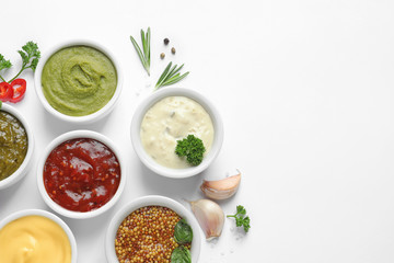 Composition with different sauces and ingredients on white background, flat lay. Space for text