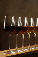 Glasses of different wines against blurred background. Expensive collection