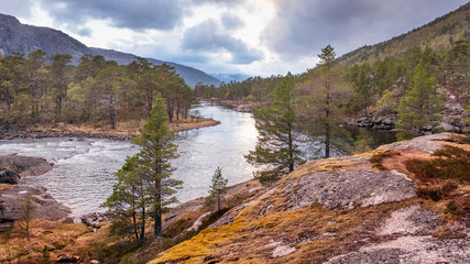  Landscape of Norway. Colorful sunset over the river in the forest in the valley of the Husedalen waterfalls