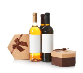 Bottles of wine and gift boxes on white background