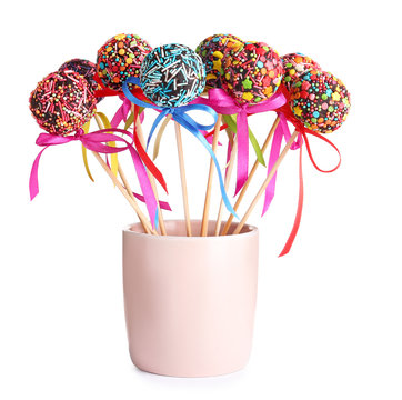 Sweet cake-pops in glass on white background
