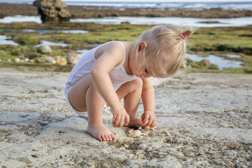 Fototapeta na wymiar Candid portrait of a happy child enjoying a day at the rocky beach