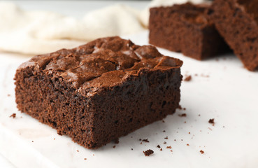 Fototapeta na wymiar Pieces of fresh brownie on white table, space for text. Delicious chocolate pie