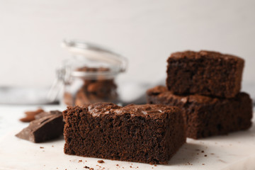 Serving board with fresh brownies on table against light background, space for text. Delicious chocolate pie