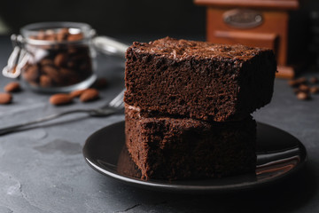 Plate with fresh brownies on grey table, space for text. Delicious chocolate pie