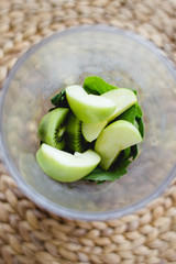 spinach, kiwi and green Apple in a glass on a wicker table