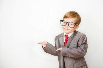 Smiling child boy pointing his index finger at something on white background. Success, creative and innovation business concept