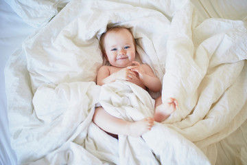 Cute little girl playing on bed