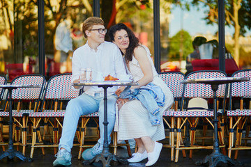 Happy romantic couple in Paris, drinking coffee