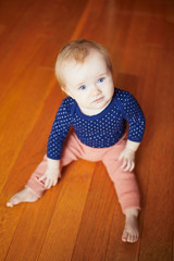 Cute baby girl sitting on the floor.