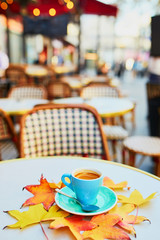 Cup of coffee on a table of traditional outdoor cafe in Paris