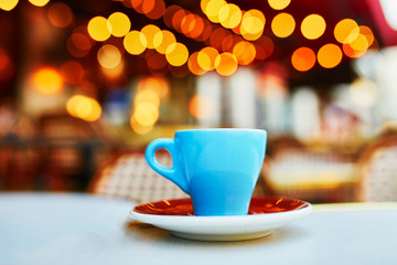 Fototapeta na wymiar Cup of fresh hot espresso coffee on table of traditional Parisian outdoor cafe in Paris