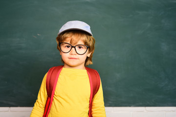 Cute boy with happy face expression near desk with school supplies. Home schooling. School kids. Learning concept