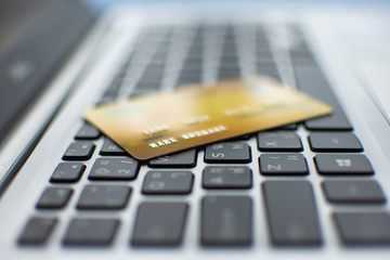 credit card on computer, shopping online concept. subject is blurred and low key.