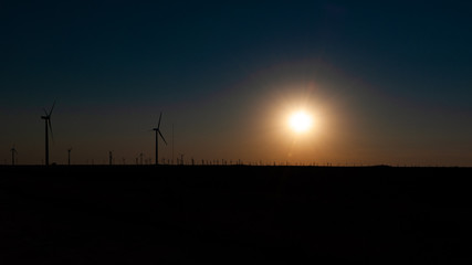 Wind generators to the horizon at sunset