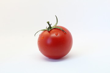 Red tomatoes with greenery on the wooden board