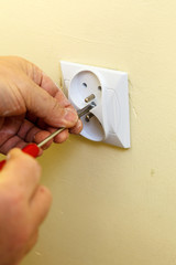 Person removing electric power socket plug