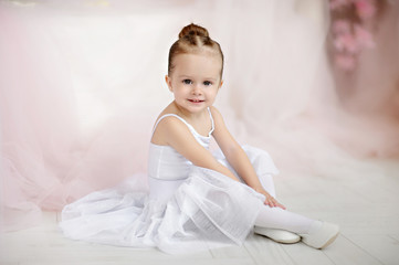 Fototapeta premium Beautiful small girl in white dress posing indoor.