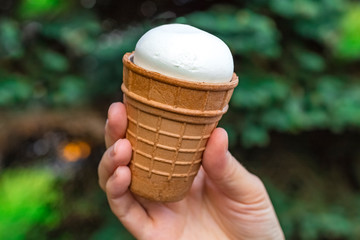 glass of ice cream in the hand of a girl, on a dark background. Toning