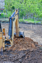 Fototapeta premium A backhoe excavating earth in a construction site