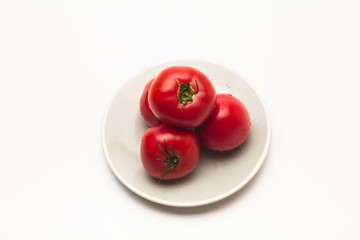  Red tomatoes in a plate on white background 