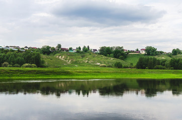 Fototapeta na wymiar The houses are located on a hill in the countryside. Valley of the Desna River