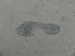 Trace de pas mouillé sur un sol de bitume sec
