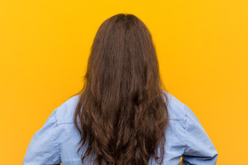 Young curvy plus size woman from behind, looking back.