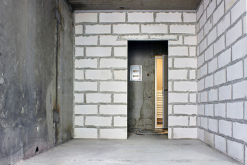 Small apartment without repair in a new building. A room in an unfinished house. Walls of foam block and concrete floor in a tiny apartment.