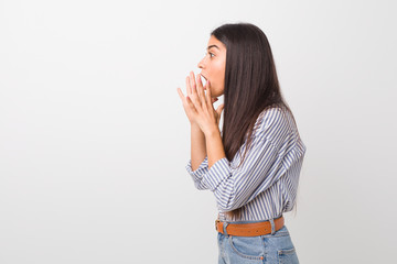 Young pretty arab woman shouts loud, keeps eyes opened and hands tense.