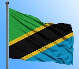 Tanzania flag waving in the deep blue sky background. Isolated national flag. Macro view shot.
