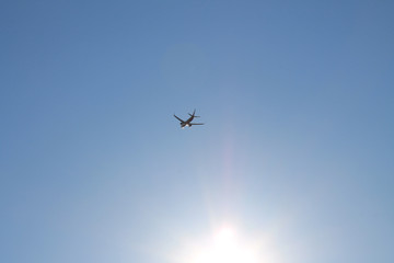 Flying plane in the blue sky with clouds