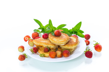 fried sweet pancakes with ripe strawberries in a plate