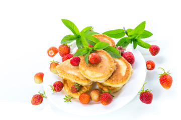 fried sweet pancakes with ripe strawberries in a plate